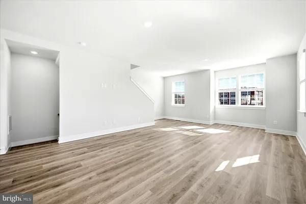 a view of empty room with wooden floor and windows