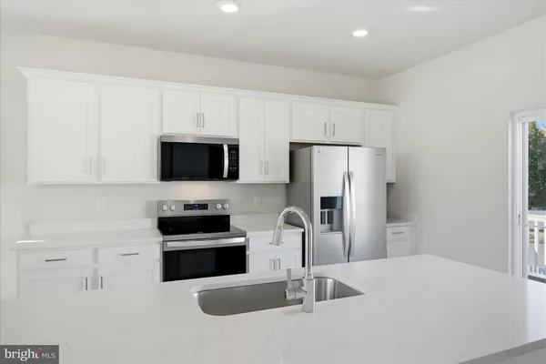 a kitchen with stainless steel appliances a refrigerator and a stove top oven