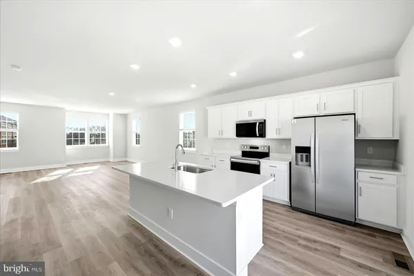 a kitchen with stainless steel appliances a stove sink microwave and cabinets