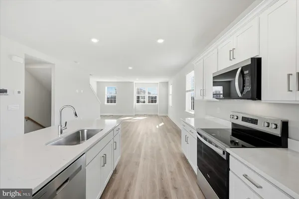 a kitchen with a sink and wooden floor