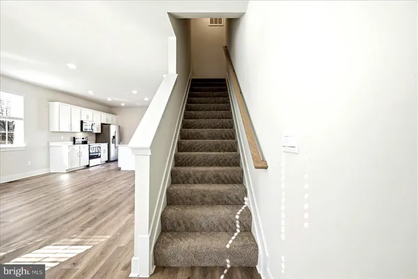 a view of a hallway with wooden floor and windows