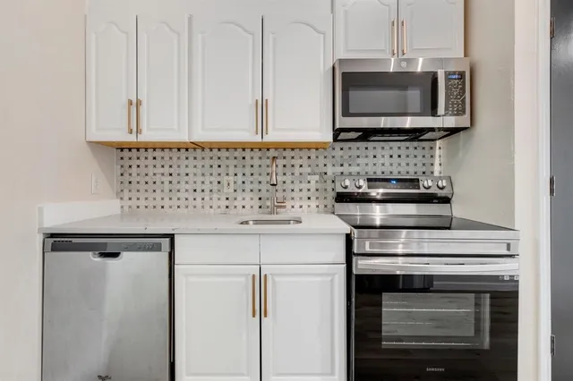 a kitchen with microwave cabinets and stove top oven