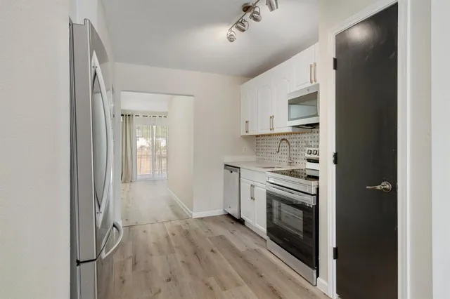 a kitchen with stainless steel appliances granite countertop a stove and a refrigerator