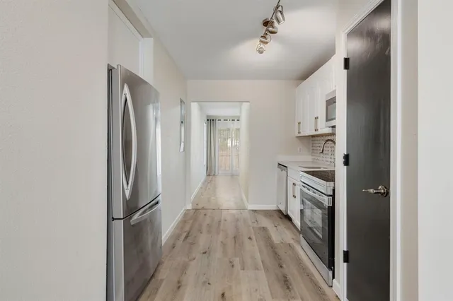 a view of kitchen with sink and refrigerator
