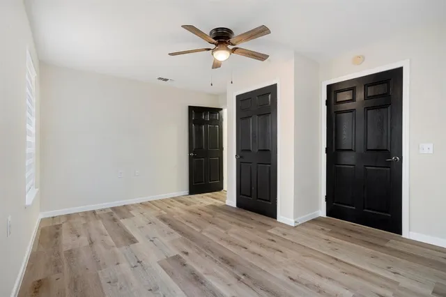 a view of an empty room with wooden floor