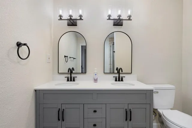 a bathroom with a double vanity sink and a toilet