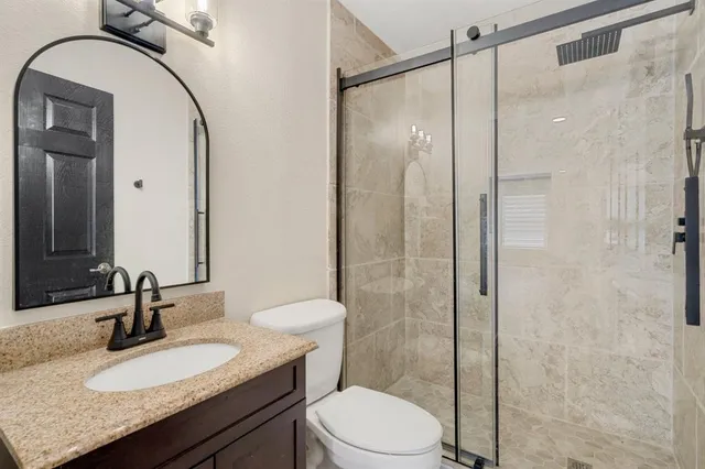 a bathroom with a granite countertop sink toilet and shower
