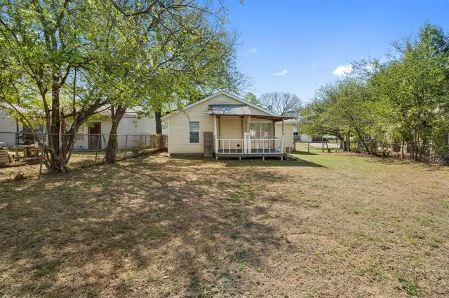 a white house that has a tree in front of it