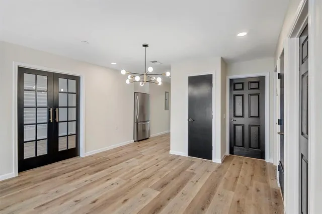 a view of empty room with wooden floor and large window