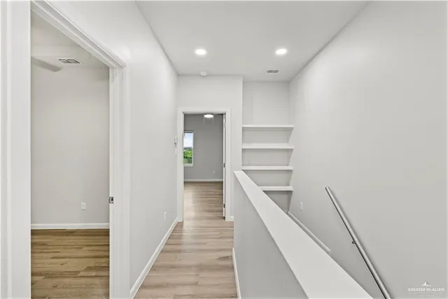 a view of a hallway with wooden floor and entryway