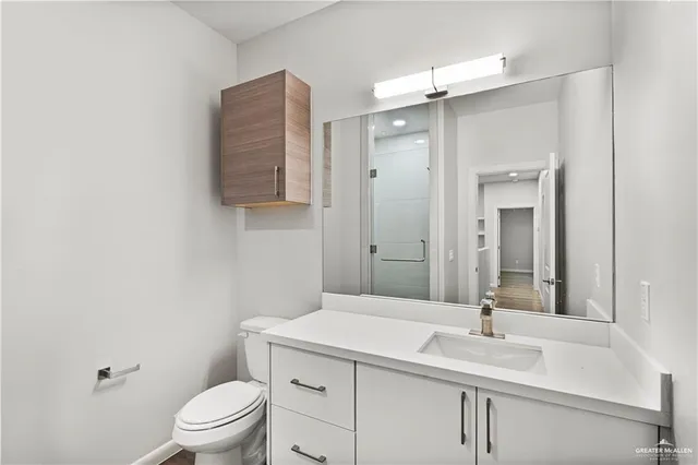 a bathroom with a granite countertop sink a toilet and a mirror