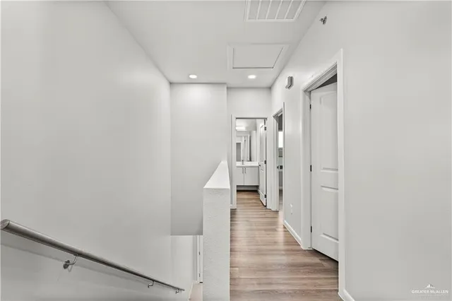 a view of a hallway with wooden floor