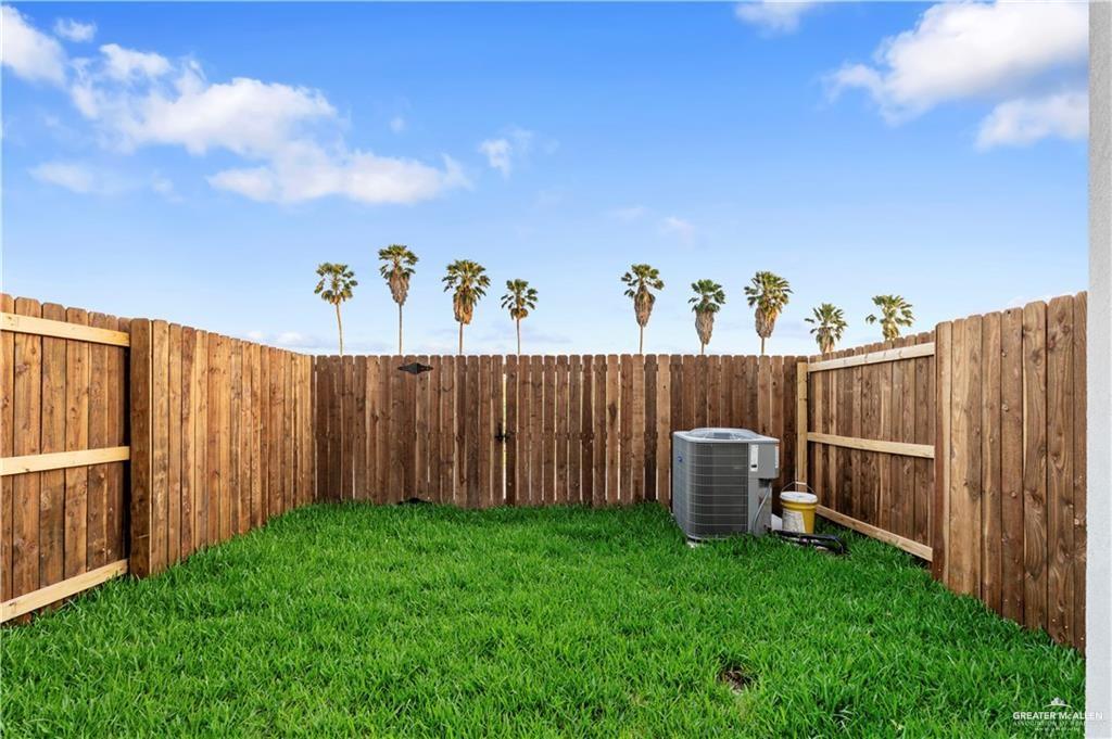 3512 Vanessa Lane, Unit 2 Weslaco, TX 78599 - Photo 20 of 21 a view of a backyard with a barbeque and wooden fence