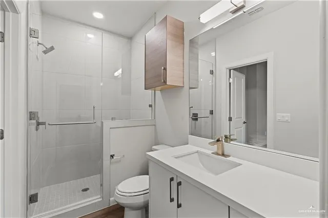 a bathroom with a sink toilet a mirror and shower