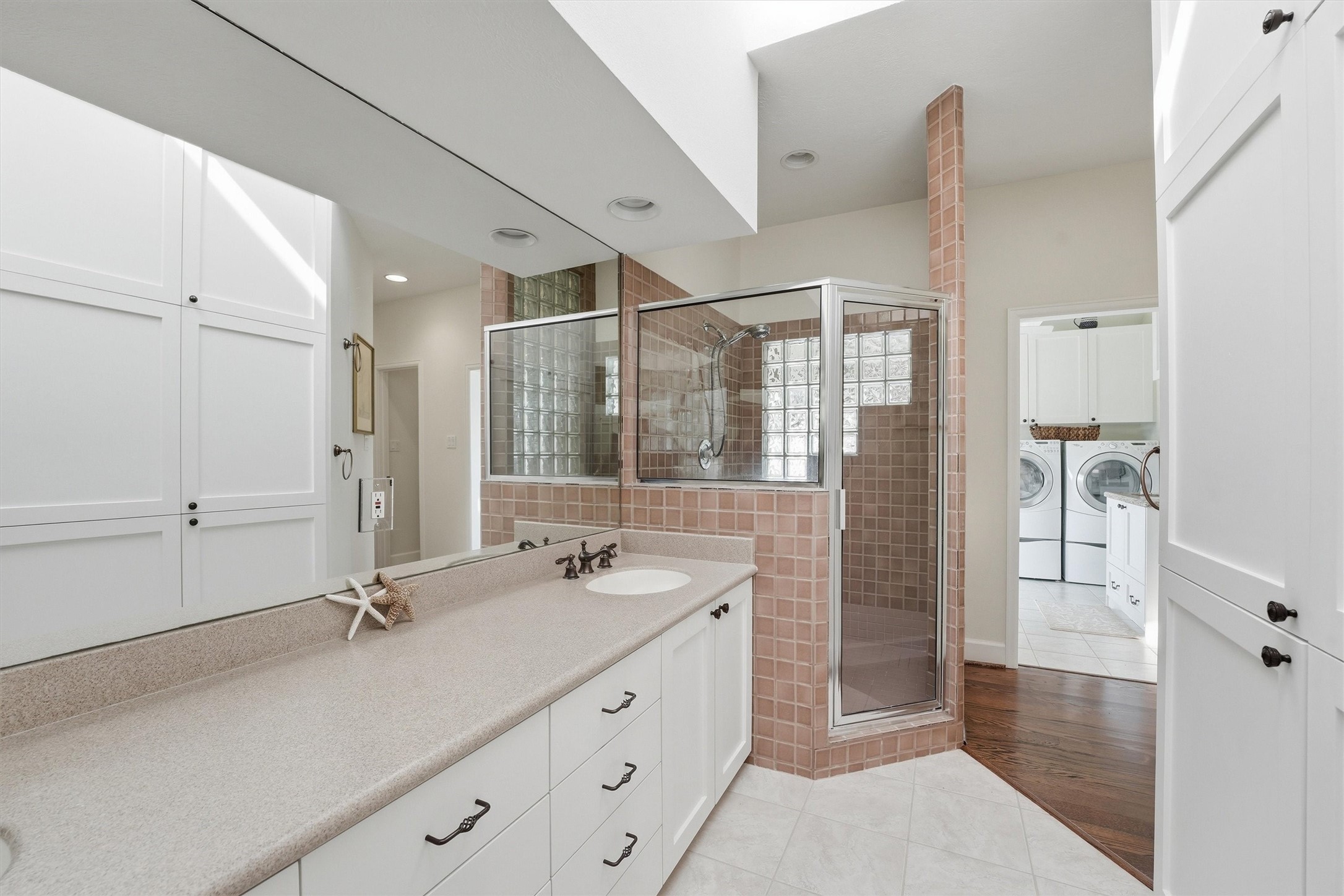 16635 Jamaica Cove Road Jamaica Beach, TX 77554 - Photo 21 of 45 a bathroom with a double vanity sink a mirror and a shower