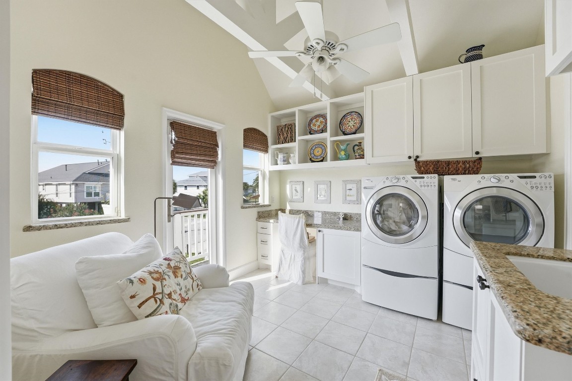 16635 Jamaica Cove Road Jamaica Beach, TX 77554 - Photo 23 of 45 Spacious, functional and stylish utility room with washer, dryer, and storage cabinetry.