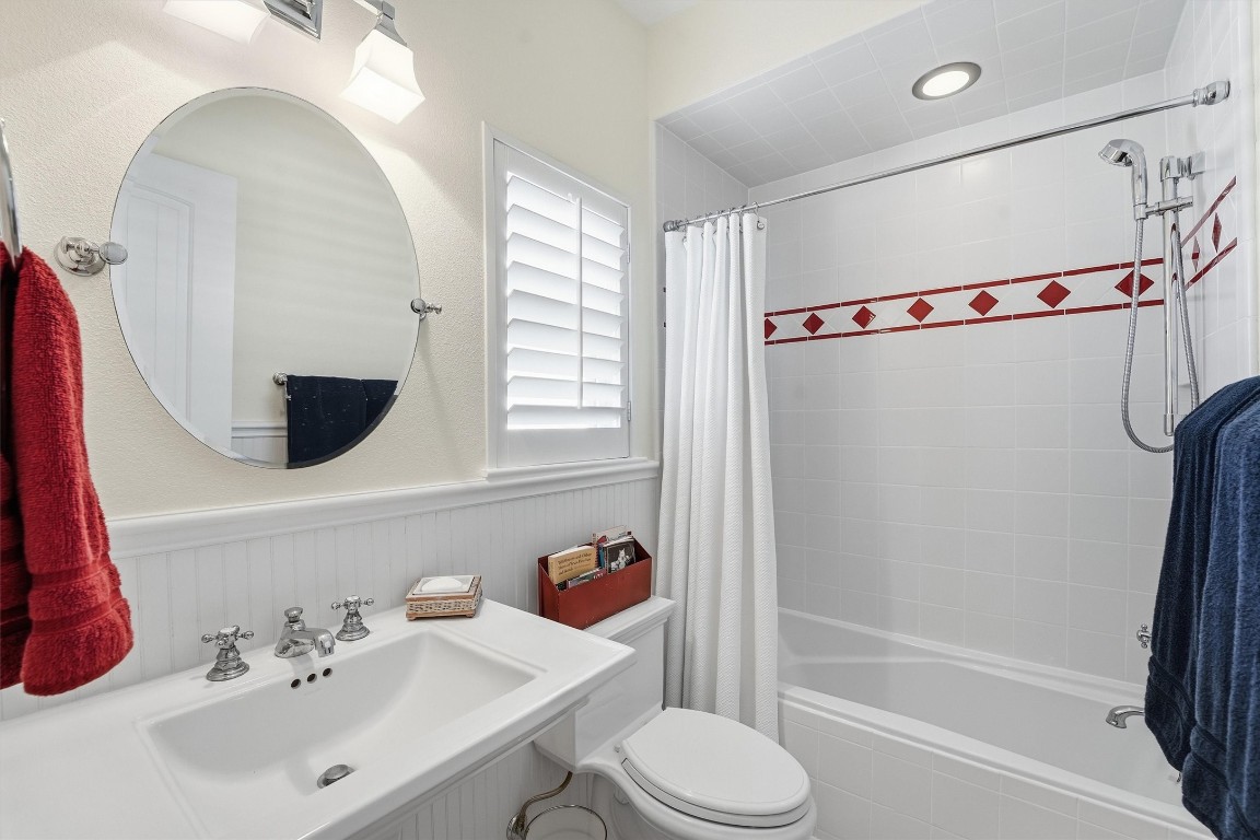 16635 Jamaica Cove Road Jamaica Beach, TX 77554 - Photo 26 of 45 a bathroom with a sink a toilet and a mirror