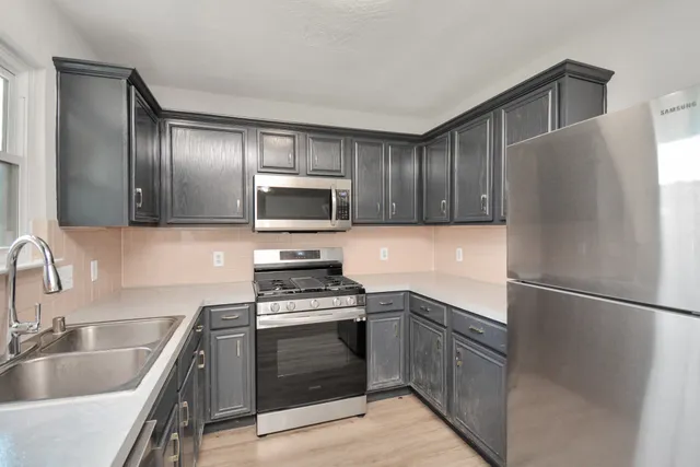 a kitchen with stainless steel appliances a sink stove and refrigerator