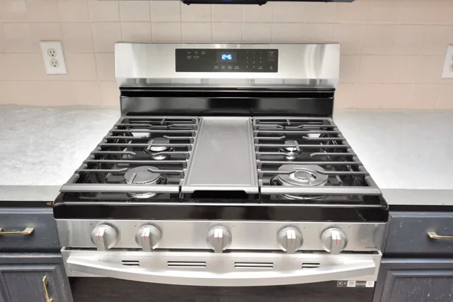 a kitchen with stainless steel appliances a sink stove and microwave