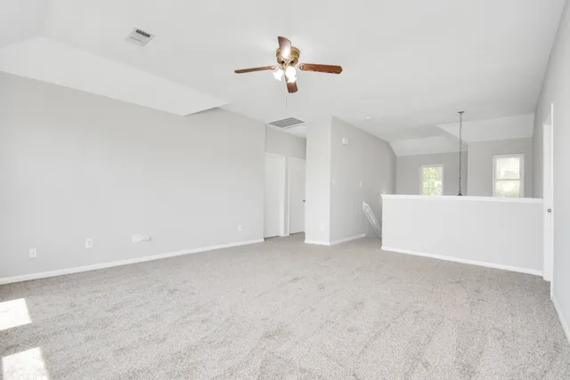 an empty room with a ceiling fan and window