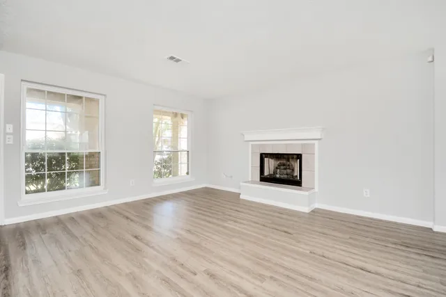 an empty room with wooden floor and a window