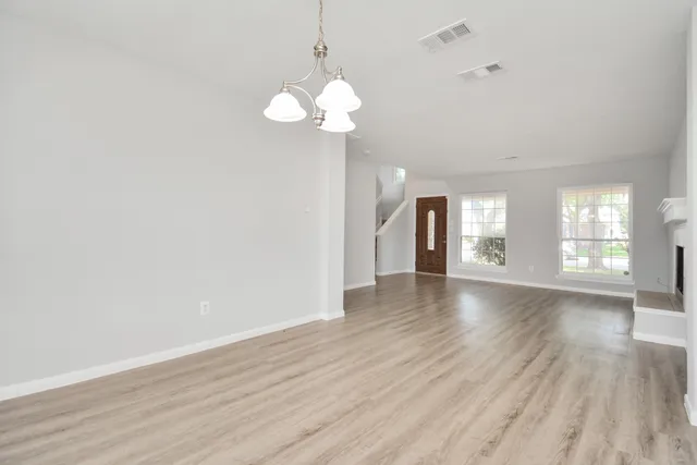 an empty room with wooden floor and fireplace