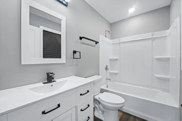 a bathroom with a sink a toilet a mirror and shower