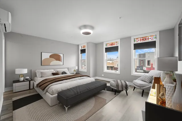 a bedroom with a bed couch and a large window