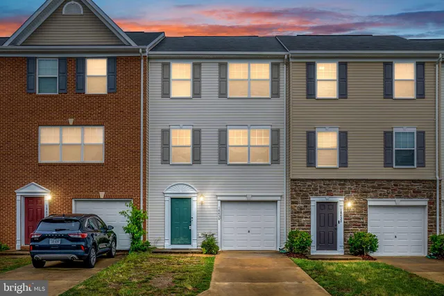 a front view of a house with a yard and a garage