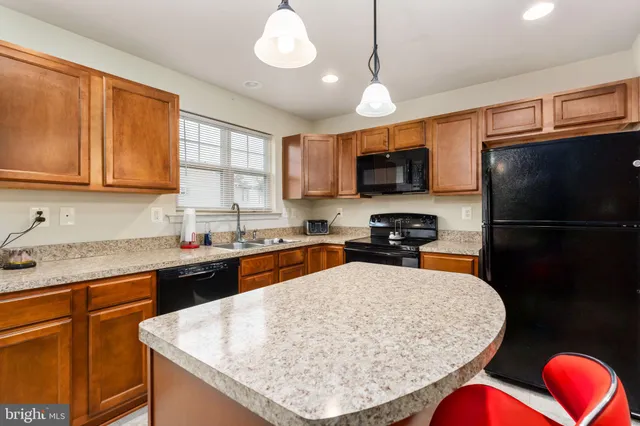 a kitchen with stainless steel appliances granite countertop a sink refrigerator stove microwave and cabinets