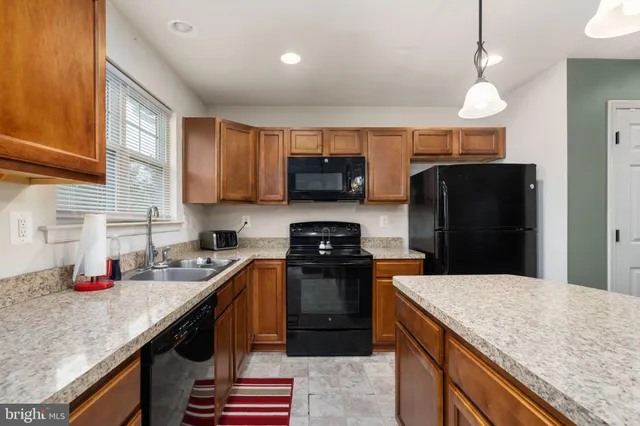 a kitchen with stainless steel appliances granite countertop a sink a stove and a refrigerator
