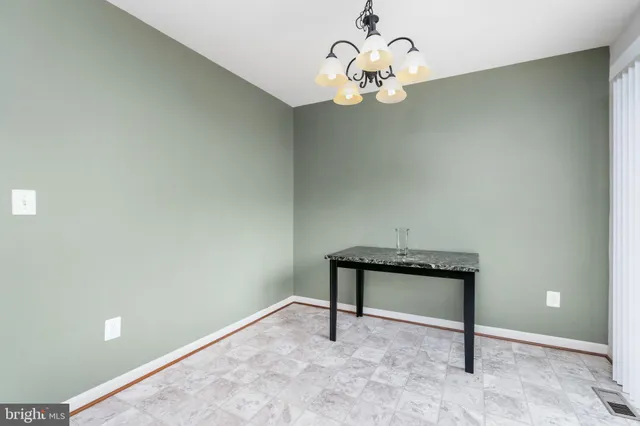 a view of a room with a hanging light and hardwood