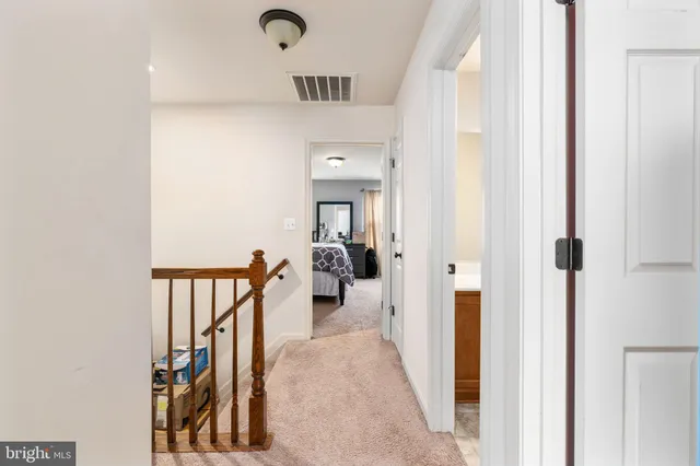 a view of a hallway with a closet and a bathroom