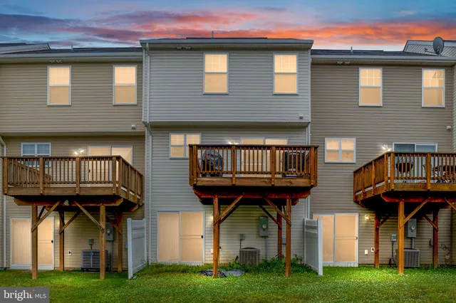 a view of a brick house with many windows and a yard