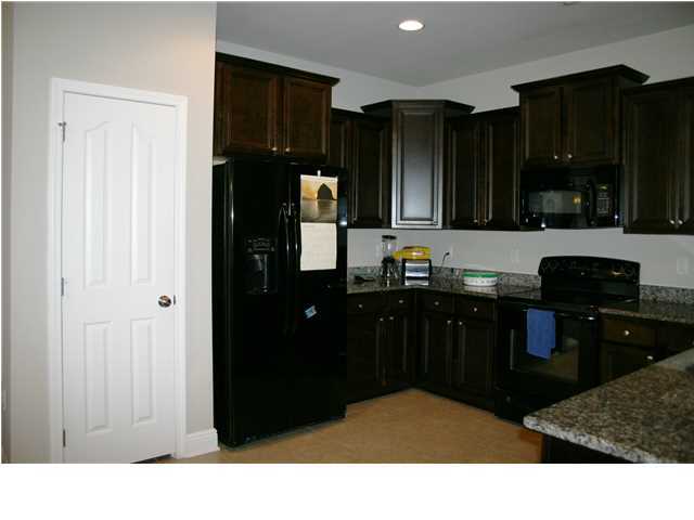 658 Red Fern Road Crestview, FL 32536 - Photo 6 of 20 a kitchen with stainless steel appliances kitchen island granite countertop a refrigerator and cabinets