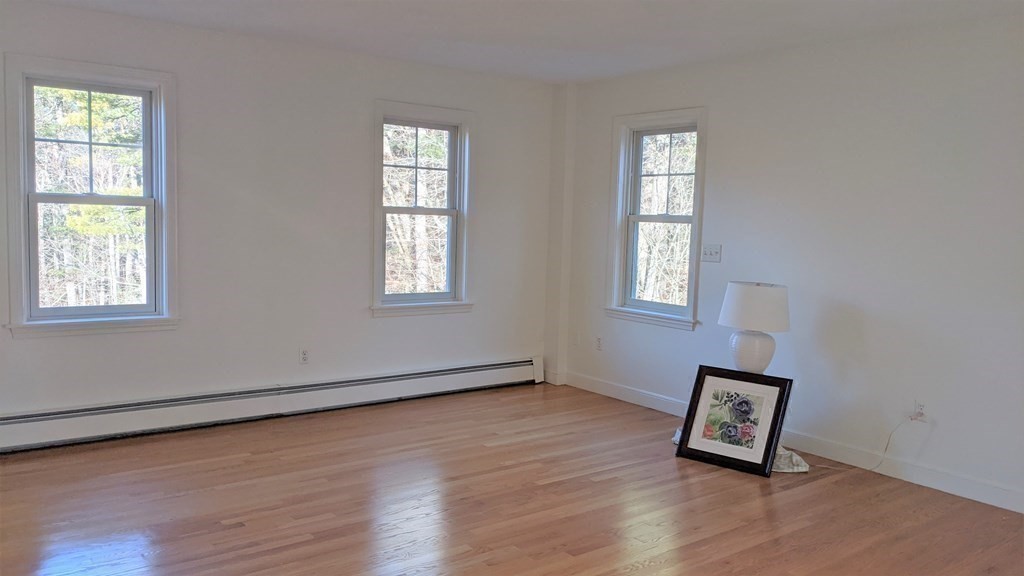 92 Lyman Road Berlin, MA 01503 - Photo 20 of 32 an empty room with windows and wooden floor