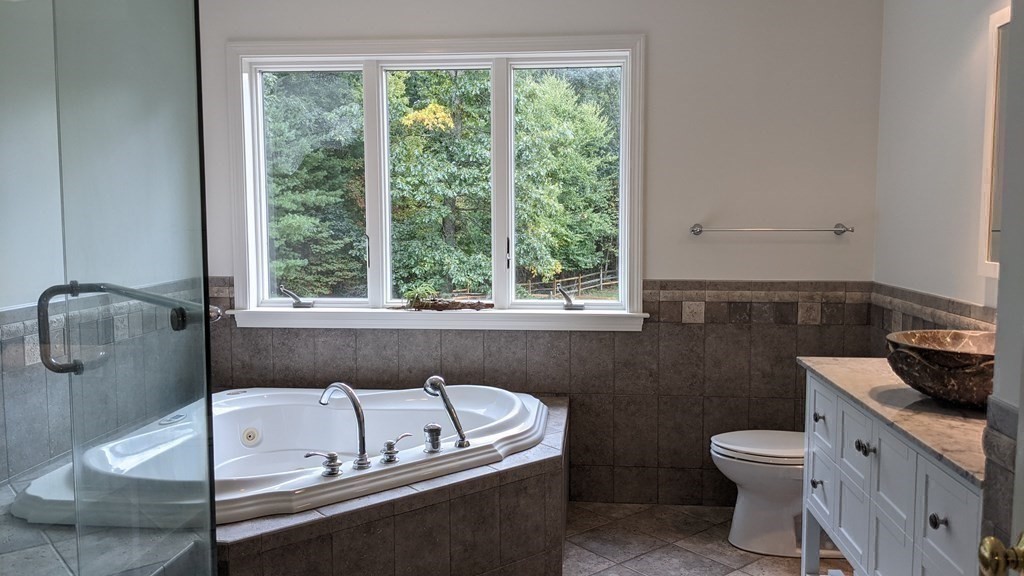 92 Lyman Road Berlin, MA 01503 - Photo 21 of 32 a bathroom with a granite countertop toilet a sink and a bathtub