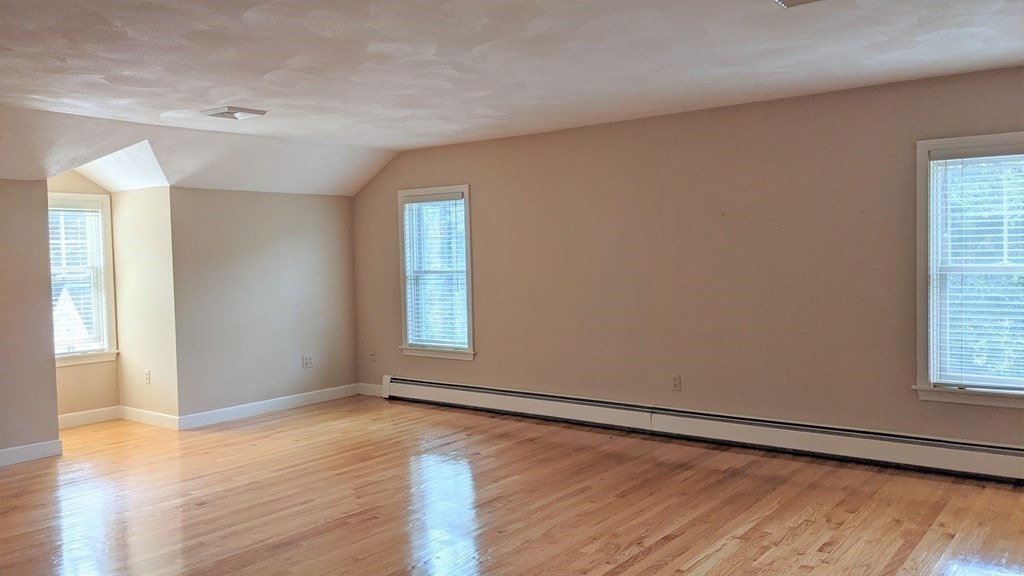 92 Lyman Road Berlin, MA 01503 - Photo 25 of 32 an empty room with wooden floor and windows with curtains