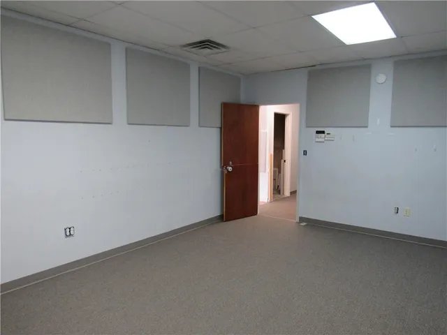 an empty room with closet and windows