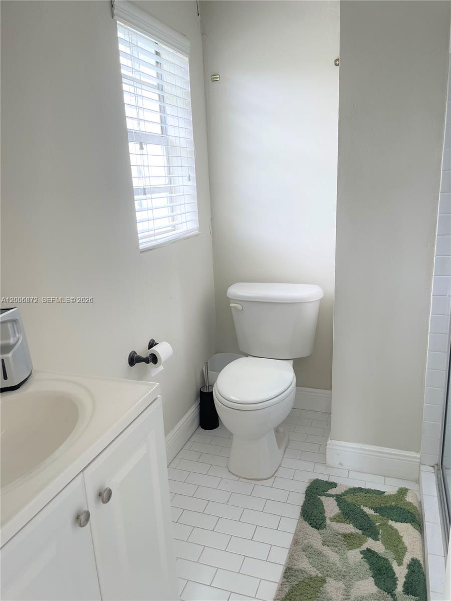 5116 Southwest 57th Avenue, Unit B Miami, FL 33155 - Photo 11 of 26 a bathroom with a toilet sink and mirror