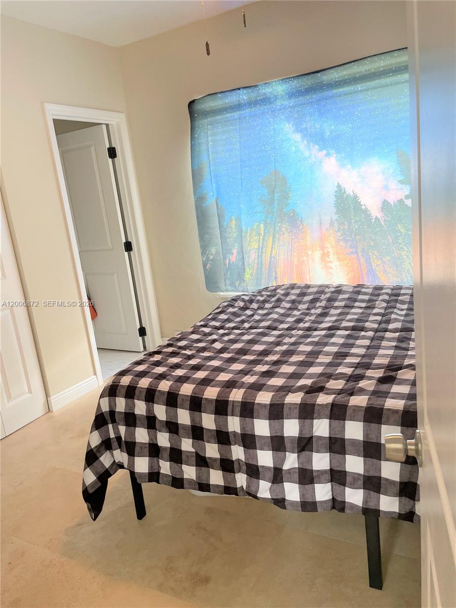 5116 Southwest 57th Avenue, Unit B Miami, FL 33155 - Photo 14 of 26 a bedroom with a bed and wooden floor