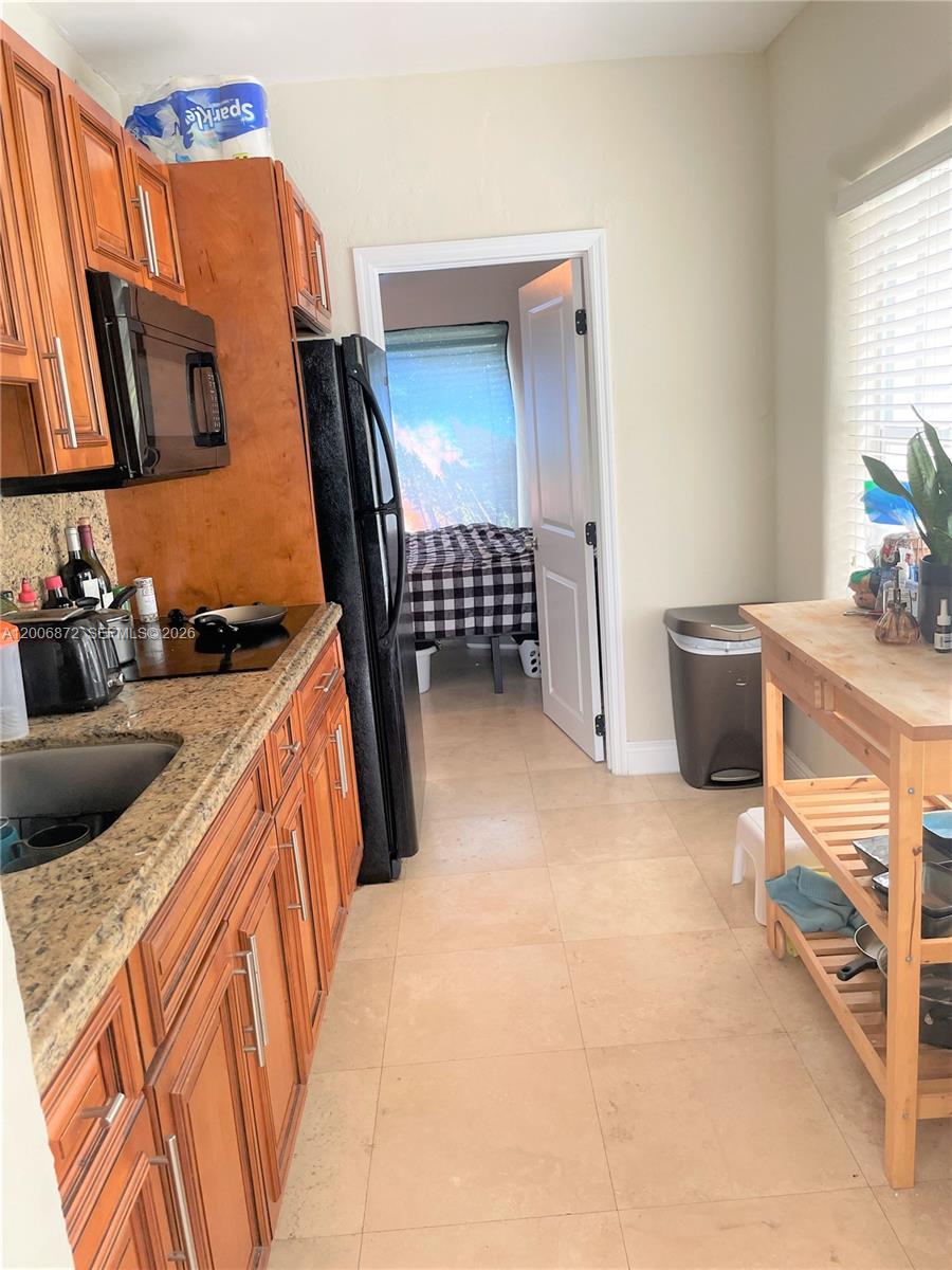 5116 Southwest 57th Avenue, Unit B Miami, FL 33155 - Photo 15 of 26 a kitchen with stainless steel appliances granite countertop a sink stove and cabinets