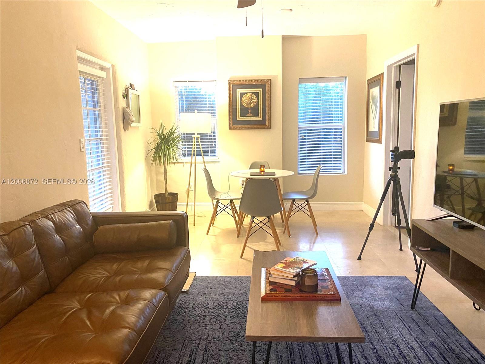 5116 Southwest 57th Avenue, Unit B Miami, FL 33155 - Photo 10 of 26 a living room with furniture a rug and a flat screen tv