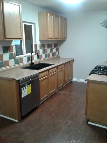 a kitchen with granite countertop a sink a stove and cabinets