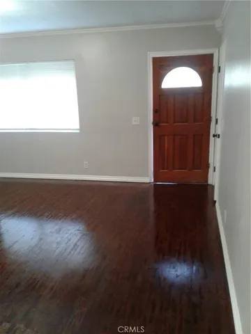 an empty room with wooden floor and a mirror