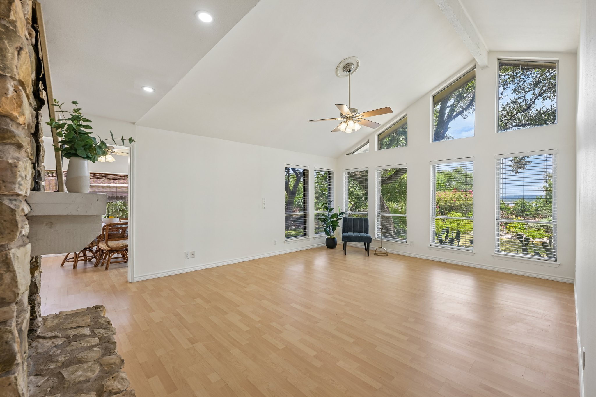 13101 Travis View Loop Austin, TX 78732 - Photo 4 of 27 Vast windows illuminate this spacious room, featuring vaulted ceilings and a beautiful lake view peeking through in the distance.