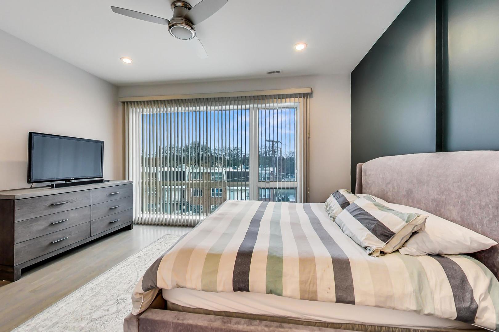 4042 North Pulaski Road, Unit 3W Chicago, IL 60641 - Photo 13 of 33 a bedroom with a bed and a flat screen tv