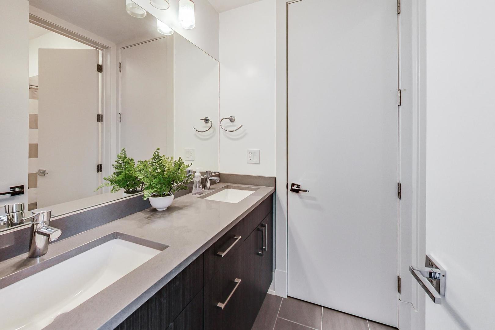 4042 North Pulaski Road, Unit 3W Chicago, IL 60641 - Photo 24 of 33 a bathroom with a granite countertop sink a mirror and a shower