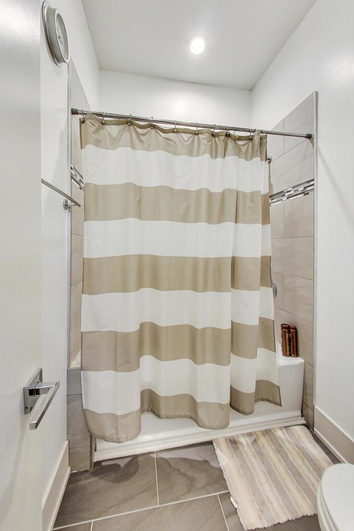 4042 North Pulaski Road, Unit 3W Chicago, IL 60641 - Photo 25 of 33 a bathroom with a bathtub and shower