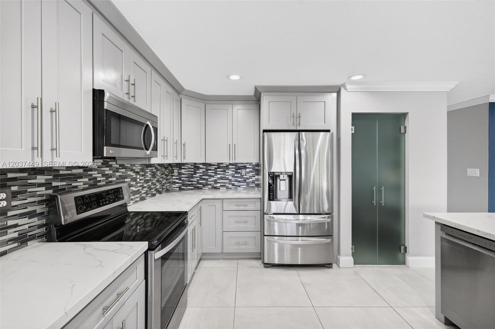 17488 Southwest 28th Court Miramar, FL 33029 - Photo 19 of 50 a kitchen with white cabinets and stainless steel appliances